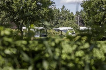 Afbeelding van een camper en kampeertent.