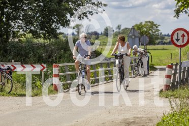 fietser op een brugje op het platteland