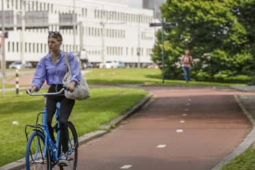 Afbeelding van een fietser op het fietspad en een rennend iemand op de achtergrond.