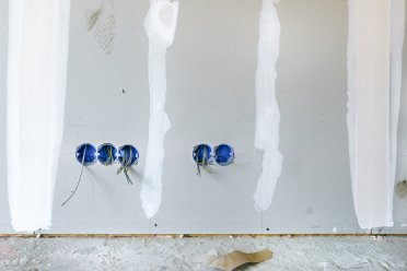 Afbeelding van betonnen muur met elektrische kabels.
